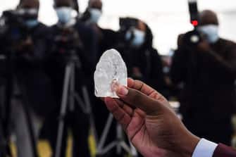 A Botswana member of cabinet holds a gem diamond in Gaborone, Botswana, on June 16, 2021. - Botswanan diamond firm Debswana said on June 16, 2021 it had unearthed a 1,098-carat stone that it described as the third largest of its kind in the world.
The stone, found on June 1, 2021 was shown to President Mokgweetsi Masisi in the capital Gaborone. (Photo by Monirul Bhuiyan / AFP) (Photo by MONIRUL BHUIYAN/AFP via Getty Images)