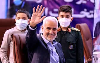 (FILES) In this file photo taken on May 13, 2021, former Iranian vice president Mohsen Mehralizadeh, accompanied by his grandsons, salutes supporters as he registers his candidacy at the Interior Ministry in the capital Tehran, for the Islamic Republic's upcoming presidential elections. - Iran approved seven hopefuls to run in next month's presidential poll, with judiciary chief Ebrahim Raisi among the mainly ultraconservative candidates, while heavyweights Mahmoud Ahmadinejad and Ali Larijani were barred. (Photo by ATTA KENARE / AFP)
