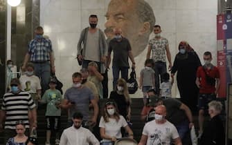 epa09282545 People wearing face masks walk in front of a portrait of Soviet Union founder Vladimir Lenin at the Metro station Biblioteka Lenina in Moscow, Russia, 18 June 2021. Over the past 24 hours, 9,056 cases of COVID-19 coronavirus infection have been detected in Moscow, which has become a new absolute record since the beginning of the pandemic. Mass entertainment events with more than 1,000 participants are prohibited in Moscow, while dance floors and fan zones for football fans are being closed.  EPA/SERGEI ILNITSKY