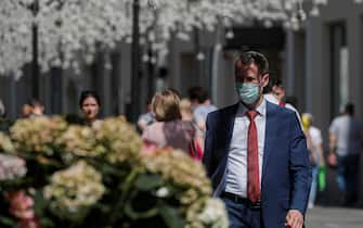 epa09283054 A man wearing a face mask walks in downtown Moscow, Russia, 18 June 2021. Over the past 24 hours, 9,056 cases of COVID-19 coronavirus infection have been detected in Moscow, which has become a new absolute record since the beginning of the pandemic.  Mass entertainment events with more than 1,000 participants are prohibited in Moscow, while dance floors and fan zones for football fans are being closed.  EPA/SERGEI ILNITSKY