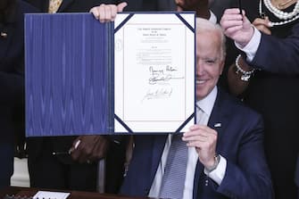 U.S. President Joe Biden holds up a signed Juneteenth National Independence Day Act during a ceremony in the East Room of the White House in Washington, D.C., U.S., on Thursday, June 17, 2021. Biden signed the legislation that will make June 19 a federal holiday commemorating the end of slavery in the United States after the House and Senate passed the bill in votes earlier this week. Photographer: Oliver Contreras/Sipa/Bloomberg via Getty Images