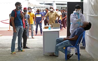 Operatore sanitario effettua un tampone per la rilevazione del coronavirus a Bangalore, in India