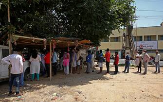 Persone in fila per un test coronavirus a Bangalore, in India