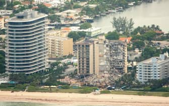 epa09304572 An aerial view of the partial collapsed 12-story condominium building in Surfside, Florida, USA, 26 June 2021. Miami-Dade Fire Rescue officials said more than 80 units responded to the collapse at the condominium building near 88th Street and Collins Avenue just north of Miami Beach on last 24 June around at 2 a.m.  EPA/CRISTOBAL HERRERA-ULASHKEVICH