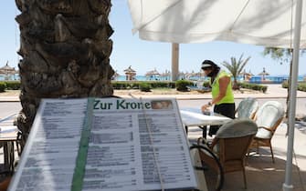 26 June 2021, Spain, Palma de Mallorca: Christian works in the bar "Zur Krone" at the beach of Arenal. The mask requirement has been considerably relaxed in Spain. Mouth-nose protection no longer has to be worn everywhere and at all times outdoors. Photo: Clara Margais/dpa (Photo by Clara Margais/picture alliance via Getty Images)