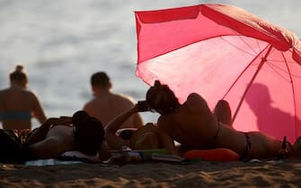 Beachgoers on English Bay Beach during a heatwave in Vancouver, British Columbia, Canada, on Monday, June 28, 2021. The heat is expected to continue for several days in some parts of British Columbia, according to weather warnings from the government. Photographer: Trevor Hagan/Bloomberg