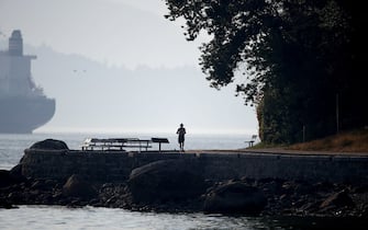 A jogger runs along the seawall next to Burrard Inlet near English Bay during a heatwave in Vancouver, British Columbia, Canada, on Monday, June 28, 2021. The heat is expected to continue for several days in some parts of British Columbia, according to weather warnings from the government. Photographer: Trevor Hagan/Bloomberg