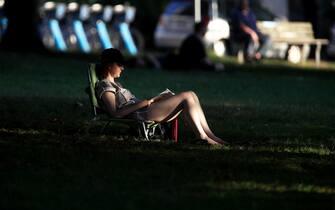 A resident reads in the shade in Alexandra Park during a heatwave in Vancouver, British Columbia, Canada, on Monday, June 28, 2021. The heat is expected to continue for several days in some parts of British Columbia, according to weather warnings from the government. Photographer: Trevor Hagan/Bloomberg