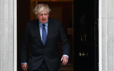 epa09271522 British Prime Minister Boris Johnson walks out the door at 10 Downing Street in London, Britain, 14 June 2021. British Prime Minister Johnson announced a month delay to lockdown easing regulations. The UK government is to delay for a further four weeks to full reopening due to a significant rise in Delta variant Covid-19 cases across England.  EPA/ANDY RAIN