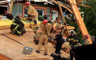 WASHINGTON, DC - JULY 01: Firefighters work to free a man trapped inside a collapsed construction site on July 01, 2021 in Washington, DC. Five people were injured when the multi-story construction site collapsed during a thunderstorm. (Photo by Chip Somodevilla/Getty Images)