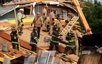 WASHINGTON, DC - JULY 01: Firefighters work to free a man trapped inside a collapsed construction site on July 01, 2021 in Washington, DC. Five people were injured when the multi-story construction site collapsed during a thunderstorm. (Photo by Chip Somodevilla/Getty Images)