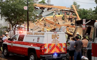 WASHINGTON, DC - JULY 01: Firefighters work to free a man trapped inside a collapsed construction site on July 01, 2021 in Washington, DC. Five people were injured when the two-story construction site collapsed during a thunderstorm. (Photo by Chip Somodevilla/Getty Images)