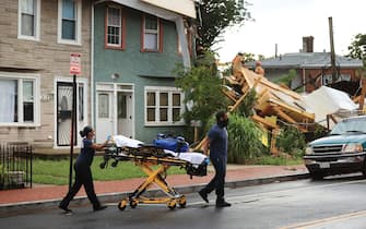 WASHINGTON, DC - JULY 01: District of Columbia Fire Department EMTs move a stretcher into place as firefighters work to rescue a man from inside a collapsed construction site on July 01, 2021 in Washington, DC. Five people were injured when the multi-story construction site collapsed during a thunderstorm. (Photo by Chip Somodevilla/Getty Images)