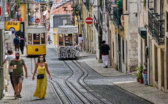 LISBON, PORTUGAL - JULY 05: Few tourists are seen walking near the Elevador da Bica, a 19th-century cable railway with 2 small cars riding up and down the sharply inclined Calçada da Bica Pequena during the COVID-19 Coronavirus pandemic on July 05, 2021 in Lisbon, Portugal. Portugal has registered so far 890,571 infections and 17,117 COVID-19-related deaths. According to data from the statistical website Our World in Data Portugal is the second country in the European Union with the most daily new cases of infection per 100,000 inhabitants in the last week, and the 20th in the world, . (Photo by Horacio Villalobos#Corbis/Corbis via Getty Images)