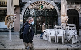 epa08938735 People walk by 'A Brasileira' cafe on the first day of new general confinement takes effect in Lisbon, Portugal, 15 January 2021.  Portugal is facing new stricter lockdown rules to be applied across the country due to the covid-19 pandemic. The country registered 10,556 new cases of infection on 14 January 2021 (a new maximum).  EPA/MARIO CRUZ