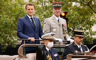 French President Emmanuel Macron and French Armies Chief of Staff General Francois Lecointre stand in the command car as they review troops prior to the annual Bastille Day military parade on the Champs-Elysees avenue in Paris on July 14, 2021. (Photo by Ludovic MARIN / POOL / AFP) (Photo by LUDOVIC MARIN/POOL/AFP via Getty Images)