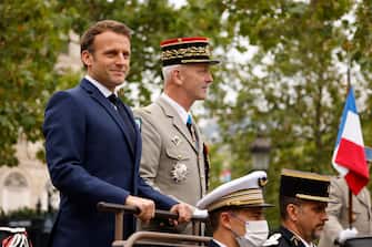 FRANCE BASTILLE DAY epa09343473 French President Emmanuel Macron (L) and French Armies Chief of Staff General Francois Lecointre (R) stand in the command car as they review troops prior to the annual Bastille Day military parade on the Champs-Elysees avenue in Paris, France, 14 July 2021. France is celebrating its national holiday with thousands of troops marching in a Paris parade and traditional parties around the country, after last year's events were scaled back because of coronavirus fears. EPA/LUDOVIC MARIN / POOL MAXPPP OUT