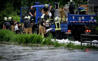 epa09344854 Firefighters and the technical relief organization move sandbags against the rising water level of the Duessel, which has already flooded large parts and streets, in Duesseldorf Grafenberg, Germany, 14 July 2021. Large parts of North Rhine-Westphalia were hit by heavy, continuous rain in the night to 14 July. According to the German Weather Service (DWD), the rain is not expected to let up until 15 July. The Rhine level has risen significantly in recent days.  EPA/SASCHA STEINBACH