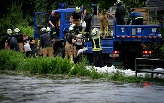 GERMANY STORM RAIN WEATHER epa09344854 Firefighters and the technical relief organization move sandbags against the rising water level of the Duessel, which has already flooded large parts and streets, in Duesseldorf Grafenberg, Germany, 14 July 2021. Large parts of North Rhine-Westphalia were hit by heavy, continuous rain in the night to 14 July. According to the German Weather Service (DWD), the rain is not expected to let up until 15 July. The Rhine level has risen significantly in recent days. EPA/SASCHA STEINBACH