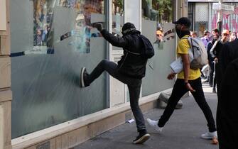 PARIS, FRANCE - JULY 14: Thousands of people, who opposed the mandatory new type of coronavirus (Covid-19) vaccine gather during a protest, on July 14, 2021 in Paris, France. Riot police intervened in protestors with tear gas, demonstrators clashed with the police, broke the windows of banks and shops, overturned trash cans and set up barricades on the roads. The demonstrators also set fire to garbage containers and construction equipment. (Photo by Alaattin Dogru/Anadolu Agency via Getty Images)