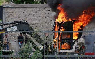 PARIS, FRANCE - JULY 14: Thousands of people, who opposed the mandatory new type of coronavirus (Covid-19) vaccine gather during a protest, on July 14, 2021 in Paris, France. Riot police intervened in protestors with tear gas, demonstrators clashed with the police, broke the windows of banks and shops, overturned trash cans and set up barricades on the roads. The demonstrators also set fire to garbage containers and construction equipment. (Photo by Alaattin Dogru/Anadolu Agency via Getty Images)