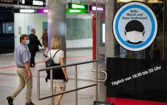 VIENNA, AUSTRIA - SEPTEMBER 14: People wearing face masks pass by a sign reading "Please cover your mouth and nose!" in the Karlsplatz underground station on September 14, 2020 in Vienna, Austria. Austrian Chancellor Sebastian Kurz announced yesterday that the country is seeing a second wave of coronavirus infections and he expects the number of daily newly reported cases to soon top 1,000. (Photo by Thomas Kronsteiner/Getty Images)