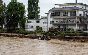 epa09349668 A digger is swept away in the flood water in Bad Neuenahr, Germany, 16 July 2021. Large parts of Western Germany were hit by heavy, continuous rain in the night to Wednesday, resulting in local flash floods that destroyed buildings and swept away cars.  EPA/CONSTANTIN ZINN