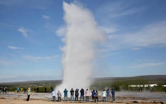 Turisti davanti a un geyser in Islanda