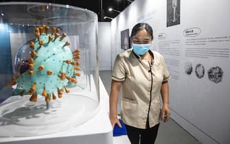 WUHAN, CHINA - JULY 18: (CHINA OUT) A cleaner wears a mask while clean the kinds of virus model at the "Enlightenment Of COVID-19" science exhibition in Wuhan Natural History Museum on July 18, 2021 in Wuhan, Hubei Province, China.  The exhibition aims to explain the unique life form of the coronavirus and the thinking behind China's fight against the pandemic, as well as exploring ways to achieve a long-term coexistence with the virus. With no recorded cases of COVID-19 community transmissions since May 2020, life for residents in Wuhan is gradually returning to normal. (Photo by Getty Images)