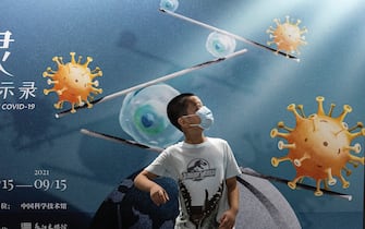 WUHAN, CHINA - JULY 18: (CHINA OUT) A boy wears a mask whilst visiting the "Enlightenment Of COVID-19" science exhibition on July 18, 2021 in Wuhan, Hubei Province, China.  The exhibition aims to explain the unique life form of the coronavirus and the thinking behind China's fight against the pandemic, as well as exploring ways to achieve a long-term coexistence with the virus. With no recorded cases of COVID-19 community transmissions since May 2020, life for residents in Wuhan is gradually returning to normal. (Photo by Getty Images)