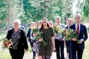 (L-R) Norway's Prime Minister Erna Solberg, Leader of Labour PartyÂ´s Youth Organization Ina RangÃ¸nes Libak, Secretary General of NATO, Jens Stoltenberg and Party leader of the Labor Party Jonas Gahr Store carry flowers during a memorial ceremony of the terror attack at Utoya, Norway on July 22, 2020. - In 2011, Breivik, disguised as a police officer, tracked and gunned down 69 people, most of them teenagers, at a Labour Party youth camp on the island of Utoya, shortly after killing eight people in a bombing outside a government building in Oslo. (Photo by Berit Roald / NTB Scanpix / AFP) / Norway OUT (Photo by BERIT ROALD/NTB Scanpix/AFP via Getty Images)