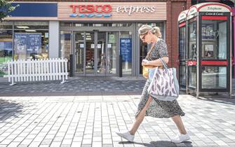 Supermercato Tesco in Inghilterra Donna davanti a un supermercato Tesco in Inghilterra