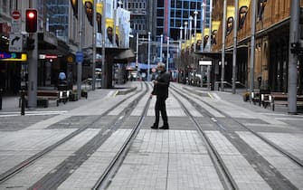 Un cittadino passeggia per le strade deserte di Sydney durante il lockdown