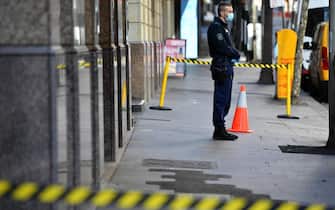 Un poliziotto sorveglia l'ingresso di un Covid hotel a Sydney