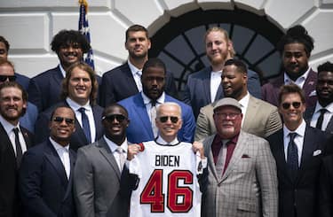 U.S. President Joe Biden, center, holds up a football jersey during a ceremony for the Tampa Bay Buccaneers on the South Lawn of the White House in Washington, D.C., U.S., on Tuesday, July 20, 2021. The Buccaneers defeated the Kansas City Chiefs 31-9 at Super Bowl LV in Tampa, Florida, on February 7. Photographer: Al Drago/Bloomberg via Getty Images