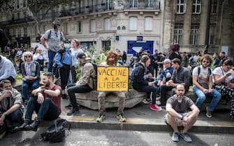 epa09382553 A protester holds a poster reading 'Vaccinated with freedom' during a demonstration against the COVID-19 health pass which grants vaccinated individuals greater ease of access to venues in France, in Paris, France, 31 July 2021. Anti-vaxxers, joined by the anti-government 'yellow vest' movement, are demonstrating across France for the third consecutive week in objection to the health pass, which is now mandatory for people to  visit leisure and cultural venues.  EPA/CHRISTOPHE PETIT TESSON
