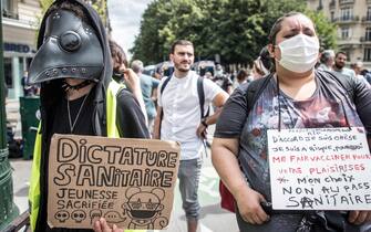 FRANCE CORONAVIRUS PANDEMIC VACCINATION PROTEST epa09382550 A protester holds a poster reading 'Sanitary Dictature, Youngness sacrified' during a demonstration against the COVID-19 health pass which grants vaccinated individuals greater ease of access to venues in France, in Paris, France, 31 July 2021. Anti-vaxxers, joined by the anti-government 'yellow vest' movement, are demonstrating across France for the third consecutive week in objection to the health pass, which is now mandatory for people to visit leisure and cultural venues. EPA/CHRISTOPHE PETIT TESSON