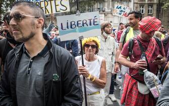 epa09382549 A protester holds a poster reading 'Freedom' during a demonstration against the COVID-19 health pass which grants vaccinated individuals greater ease of access to venues in France, in Paris, France, 31 July 2021. Anti-vaxxers, joined by the anti-government 'yellow vest' movement, are demonstrating across France for the third consecutive week in objection to the health pass, which is now mandatory for people to  visit leisure and cultural venues.  EPA/CHRISTOPHE PETIT TESSON