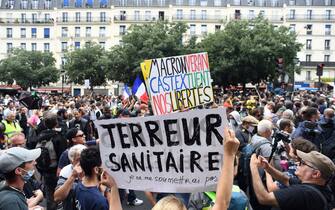 Demonstrators hold up banners and placards, one of which reads as 'Macron, Veran, Castex kill our freedom' and 'Health Terror, I will not submit myself', during a national day of protest against the compulsory Covid-19 vaccination for certain workers and the compulsory use of the health pass called for by the French government in Paris on July 31, 2021. (Photo by Alain JOCARD / AFP) (Photo by ALAIN JOCARD/AFP via Getty Images)