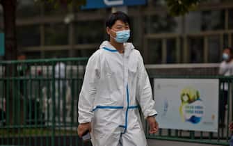 epa09376433 A man wearing a face mask and a protective suit walks at the railway station in Shanghai, China, 29 July 2021. China reported 24 new locally transmitted COVID-19 cases, according to the National Health Commission. More than 170 people have been diagnosed with the Delta variant. The main outbreak is in the eastern city of Nanjing, in Jiangsu province.  EPA/ALEX PLAVEVSKI