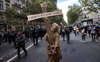 FRANCE CORONAVIRUS PANDEMIC HEALTH PASS PROTEST epa09404309 A protester dressed as Jesus holds a cross bearing the message 'the vaccine kills your immune system', during a demonstration against the COVID-19 health pass which grants vaccinated individuals greater ease of access to venues in France, in Paris, France, 07 August 2021. The national enforcement of the 'Health Pass' is expected to take effect on 09 August, after the French Constitutional Council has confirmed the government's law which extend the use of its Vaccinal Passeport (a QR code which proves the bearer has received full vaccination, or been tested negative for Covid in the last 72 hours) to cultural place, transport, and restaurants among other places. EPA/IAN LANGSDON