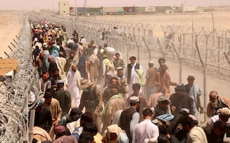 epa09412014 People stranded at the Pakistani-Afghan border wait to cross the border after it was reopened at Chaman, Pakistan, 13 August 2021. Pakistani authorities reopened the border with Afghanistan on 13 August after several days of its closure. Taliban s shadow governor for Kandahar province had on 05 August issued a statement that announced the closing down of the border with Pakistan at Chaman, and said Islamabad should relax rules for crossing the frontier.  EPA/AKHTER GULFAM