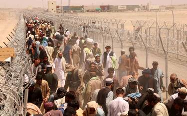 epa09412014 People stranded at the Pakistani-Afghan border wait to cross the border after it was reopened at Chaman, Pakistan, 13 August 2021. Pakistani authorities reopened the border with Afghanistan on 13 August after several days of its closure. Taliban s shadow governor for Kandahar province had on 05 August issued a statement that announced the closing down of the border with Pakistan at Chaman, and said Islamabad should relax rules for crossing the frontier. EPA/AKHTER GULFAM