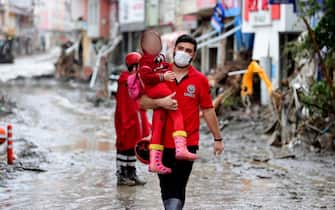 Una bambina viene soccorsa dopo i temporali che hanno colpito la regione del Mar Nero in Turchia