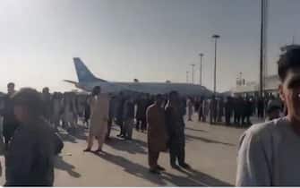 Afghani sulla pista dell'aeroporto di Kabul
