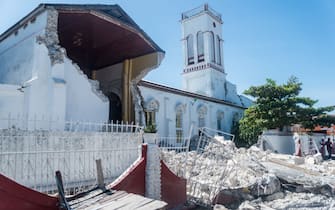 Rubble from a destroyed wall lies outside the "Sacré coeur des Cayes" church in Les Cayes on August 15, 2021, after a 7.2-magnitude earthquake struck the southwest peninsula of the country. - Hunched on benches, curled up in chairs or even lying the floor, those injured in the powerful earthquake that wreaked havoc on Haiti on Saturday crowded an overburdened hospital near the epicenter. The emergency room in Les Cayes, in southwestern Haiti, which was devastated by the 7.2-magnitude quake on Saturday morning that killed at least 724 people, is expecting reinforcements to help treat some of the thousands of injured. (Photo by Reginald LOUISSAINT JR / AFP) (Photo by REGINALD LOUISSAINT JR/AFP via Getty Images)