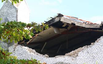 A destroyed building is seen in Les Cayes on August 15, 2021, after a 7.2-magnitude earthquake struck the southwest peninsula of the country. - Hunched on benches, curled up in chairs or even lying the floor, those injured in the powerful earthquake that wreaked havoc on Haiti on Saturday crowded an overburdened hospital near the epicenter. The emergency room in Les Cayes, in southwestern Haiti, which was devastated by the 7.2-magnitude quake on Saturday morning that killed at least 724 people, is expecting reinforcements to help treat some of the thousands of injured. (Photo by Stanley LOUIS / AFP) (Photo by STANLEY LOUIS/AFP via Getty Images)