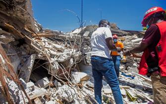 epa09415663 Personnel carry out debris removal, search and rescue work, in Les Cayes, Haiti, 15 August 2021. The United States sent an urban search and rescue team to Haiti this 15 August, the second unit to deploy in the country after the devastating earthquake on 14 August, which has left at least 724 dead and extensive material damage.  EPA/Ralph Tedy Erol