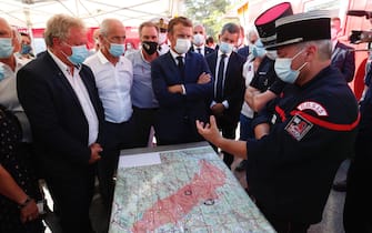 epa09418066 French President Emmanuel Macron (C), French Interior Minister Gerald Darmanin (R) and President of Paca regional council Renaud Muselier (L) visit the SDIS (Departmental fire and rescue service) and firefighters headquarter in Le Luc, near Saint-Tropez, France. Firefighters are battling wildfires and thousands of residents are evacuated in the area near St. Tropez.  EPA/GUILLAUME HORCAJUELO/POOL