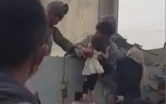 Una madre lancia il figlio oltre il filo spinato all'aeroporto di Kabul